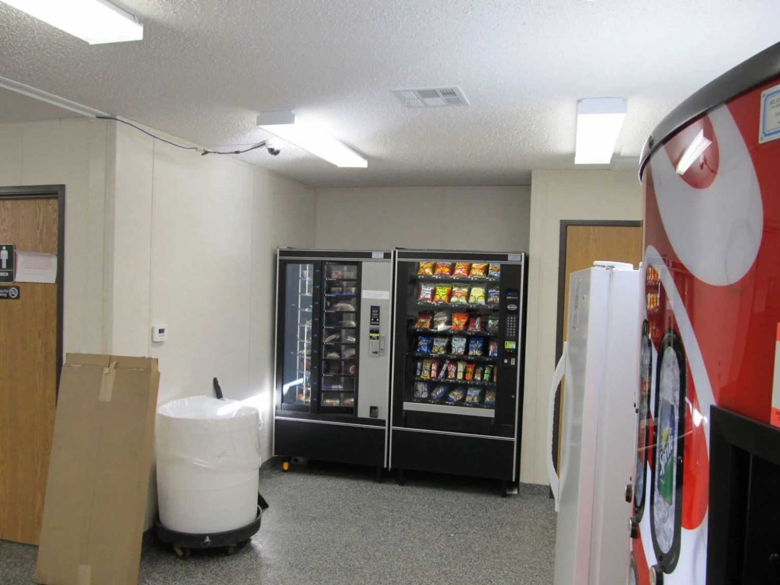 Photo of a workplace break room vending nook with older traditional machines