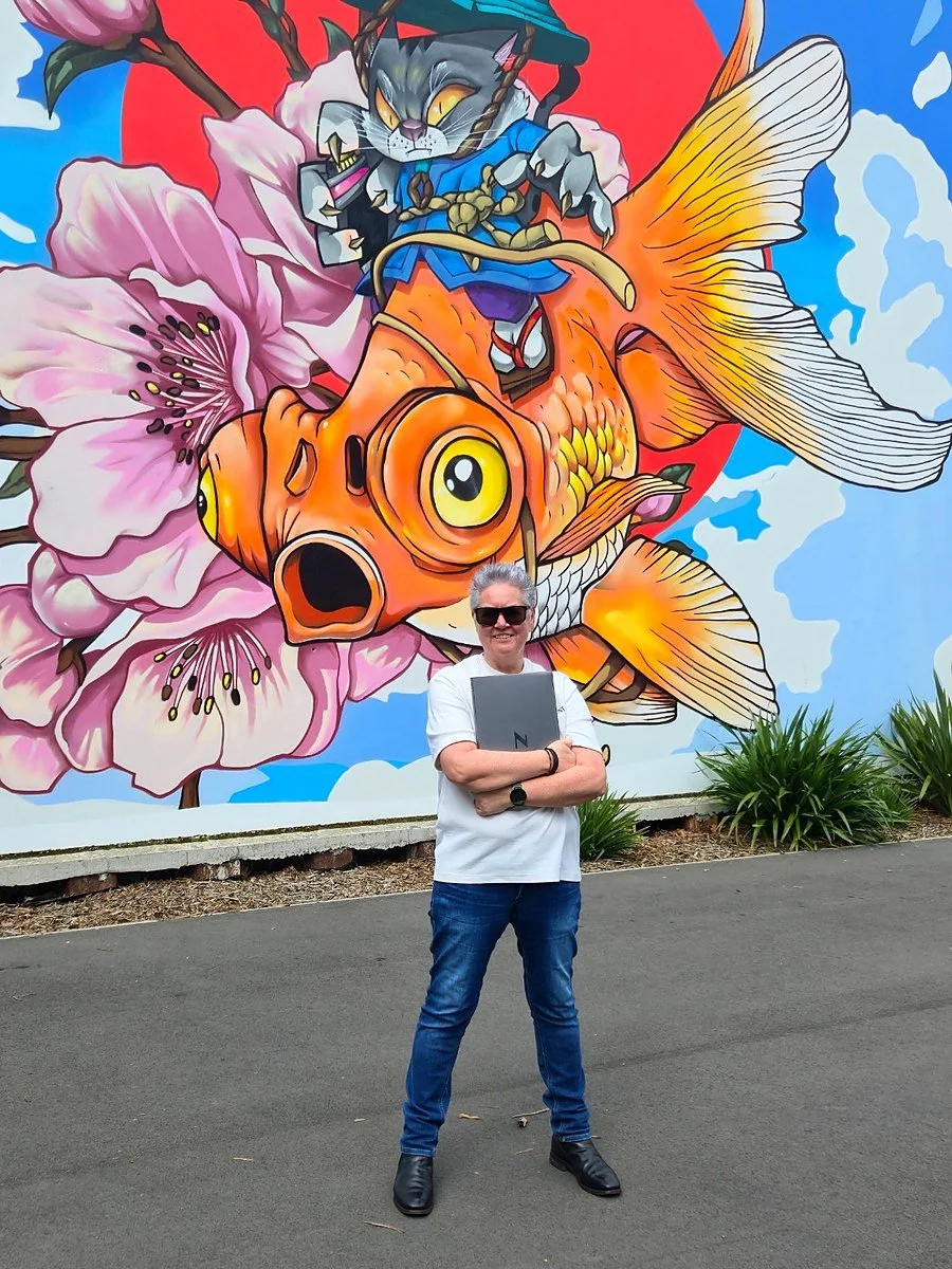 Carolyn Glasson, founder, in front of a big goldfish mural