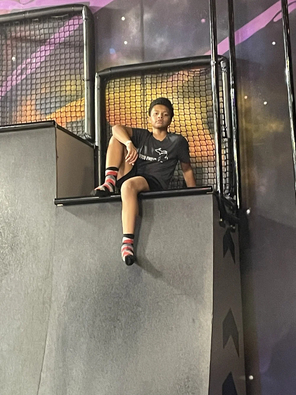 Original phone snap: phone snap of a teen giving a peace sign atop a trampoline park climbing structure