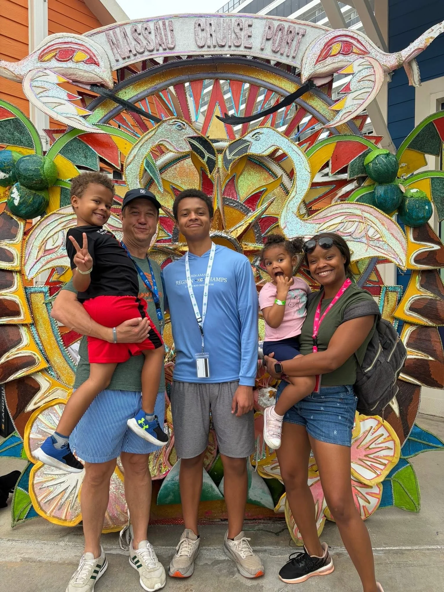 Our family on a family cruise, standing together in front of a colorful sign