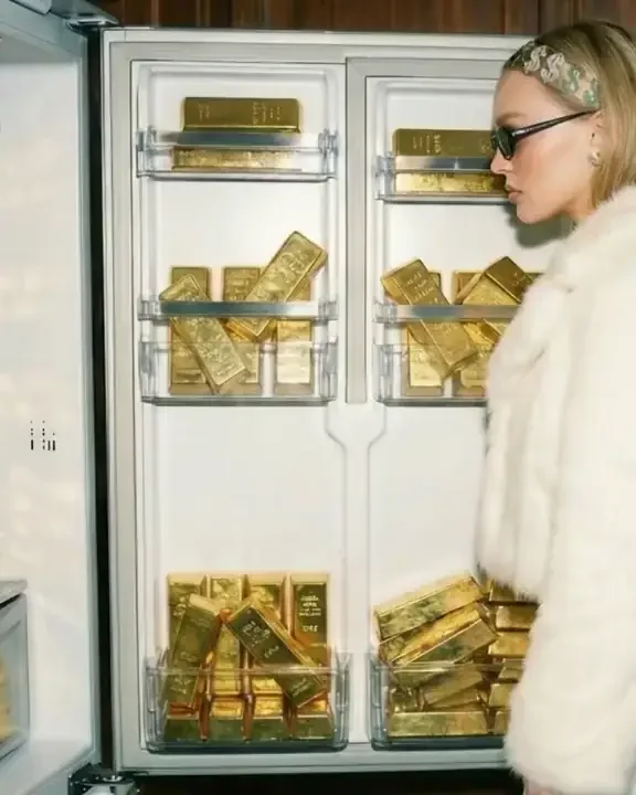 A member opening a fridge full of gold bars
