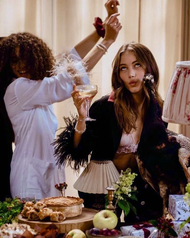 Two of the girls celebrating at a dinner party with champagne