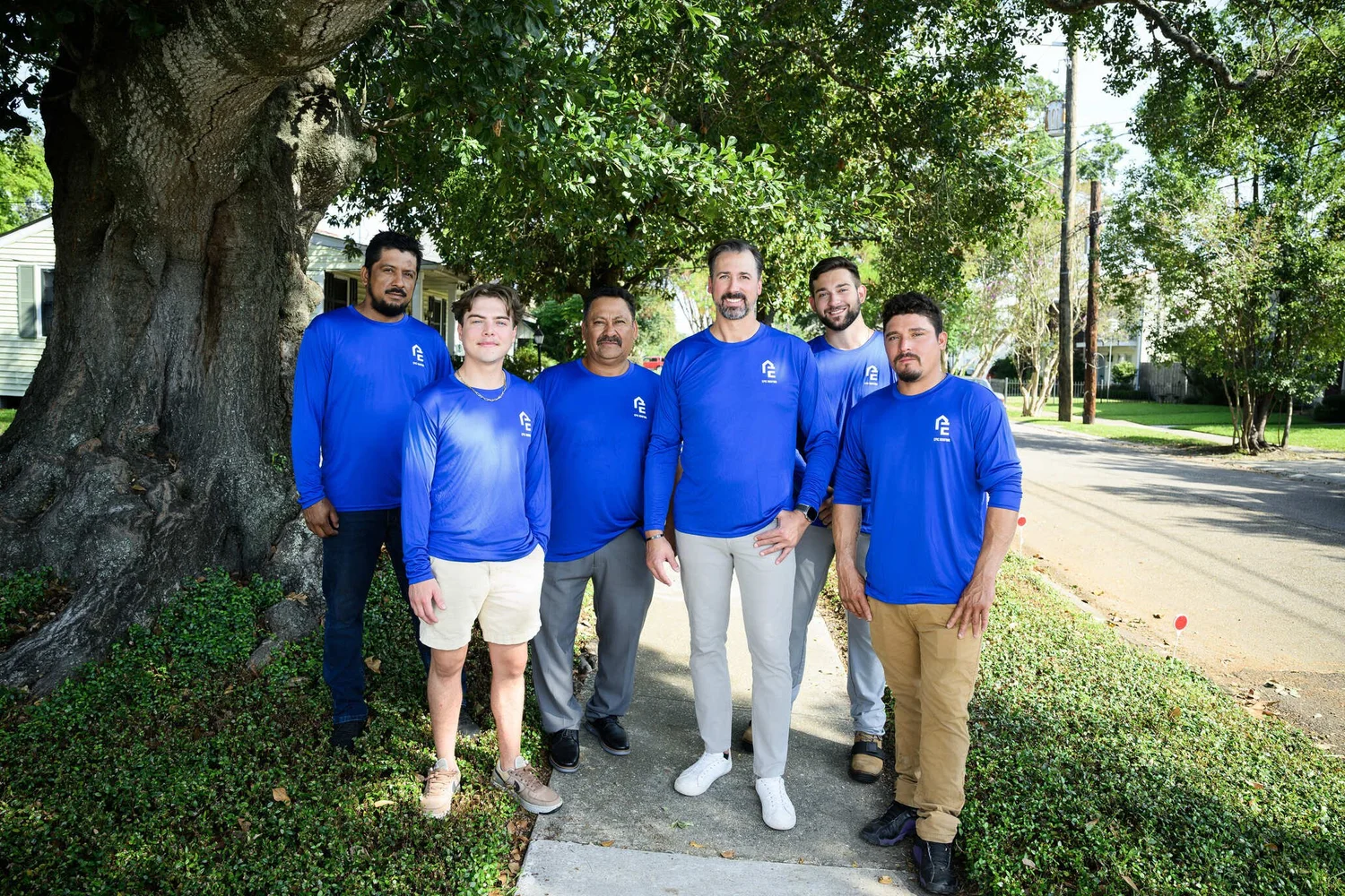 Epic Roofing crew standing together under an oak tree