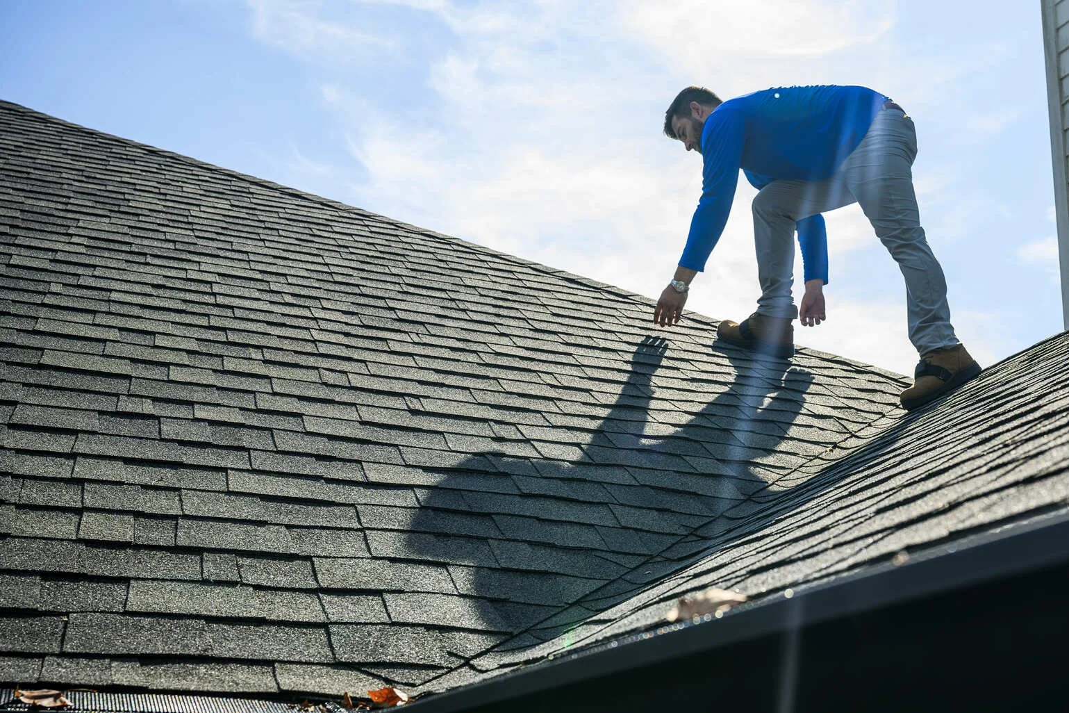 Epic Roofing crew member inspecting an architectural shingle roof in Mandeville