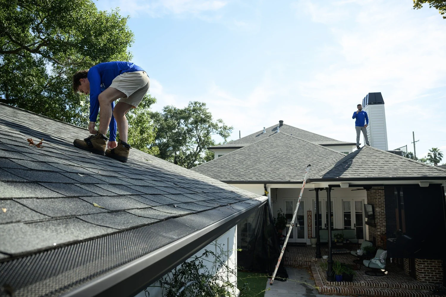 Epic Roofing crew member working along a shingle roof edge above the gutter