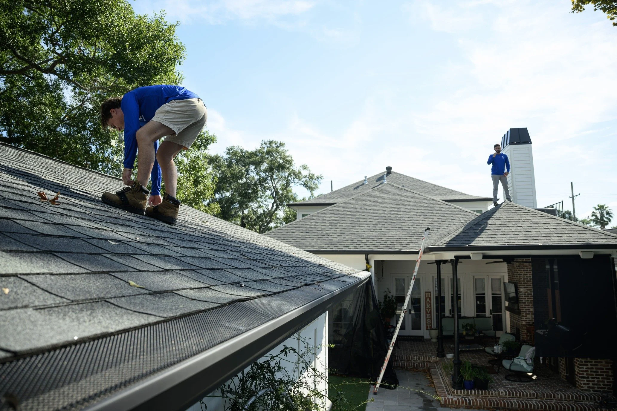 Epic Roofing crew member working along a shingle roof edge above the gutter
