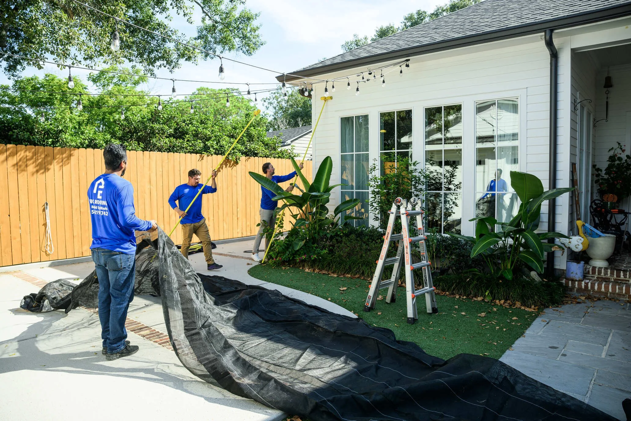 Epic Roofing crew handling heavy-duty tarp during post-storm response