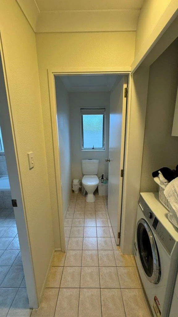Toilet and laundry before upgrade, Tauranga apartment
