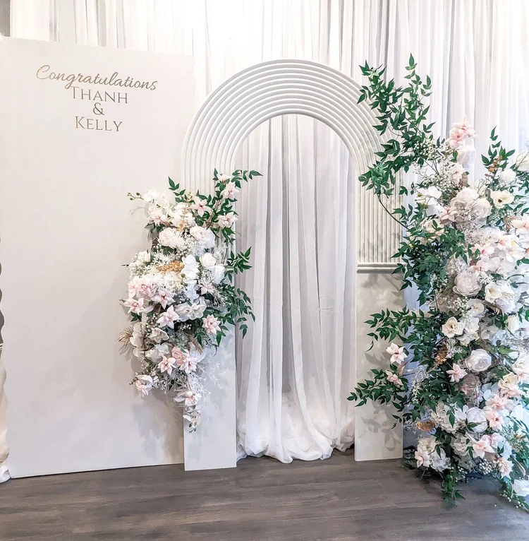Cascading silk floral accents framing a white arch backdrop
