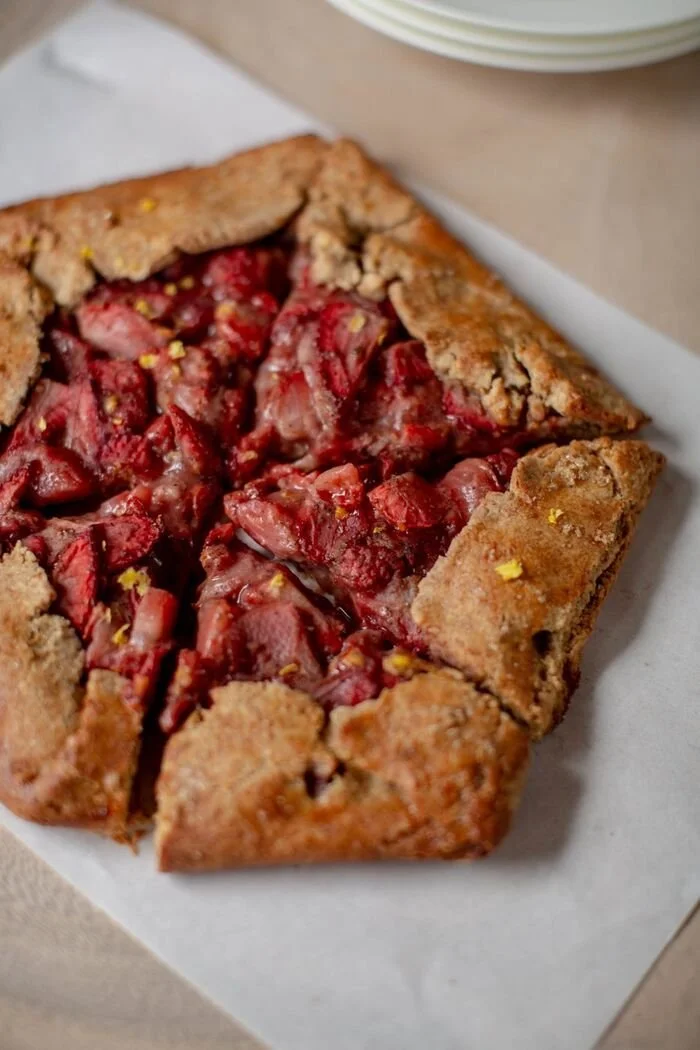 A rustic strawberry galette on parchment