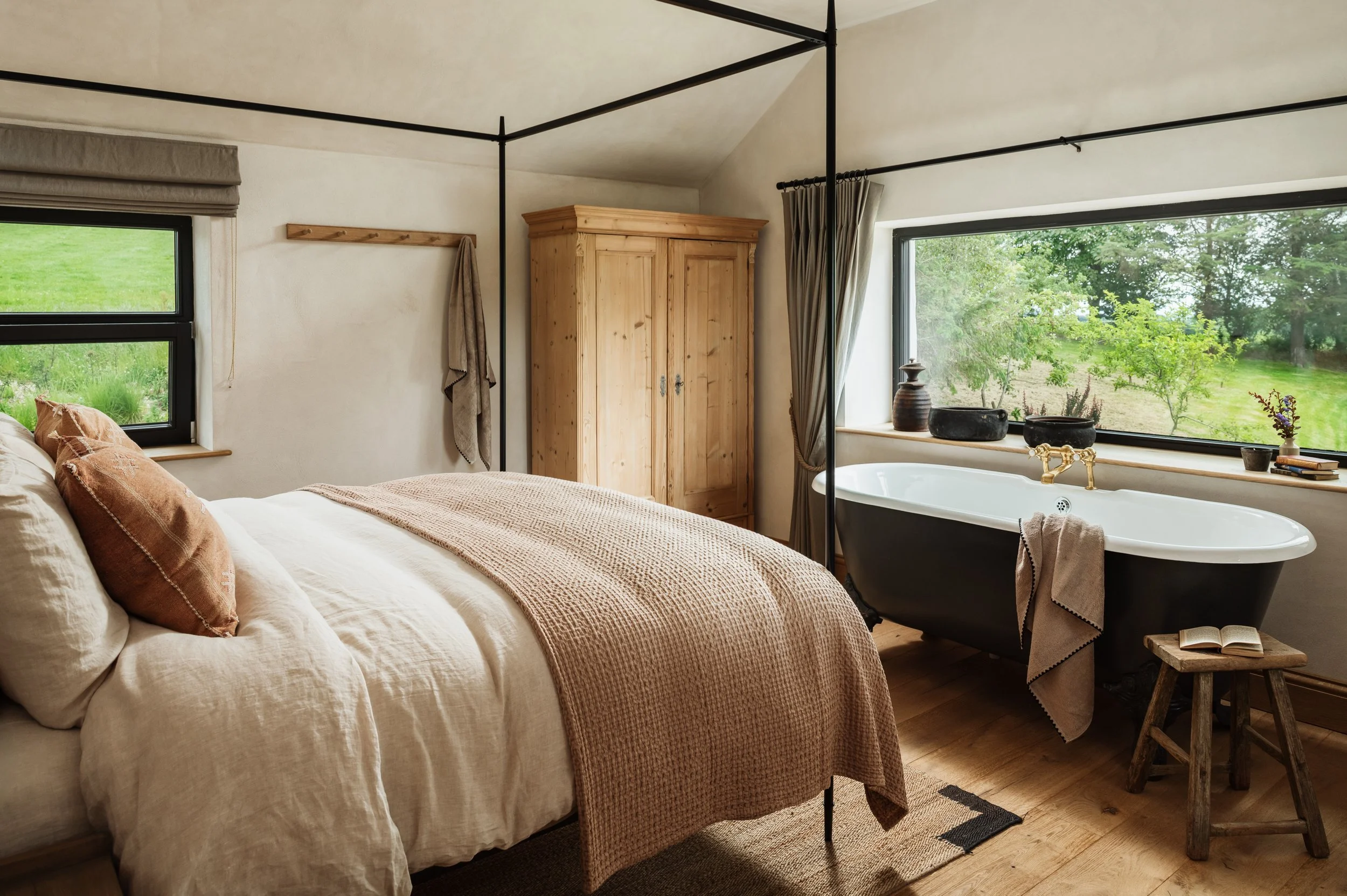 A bedroom with a bath beneath the window