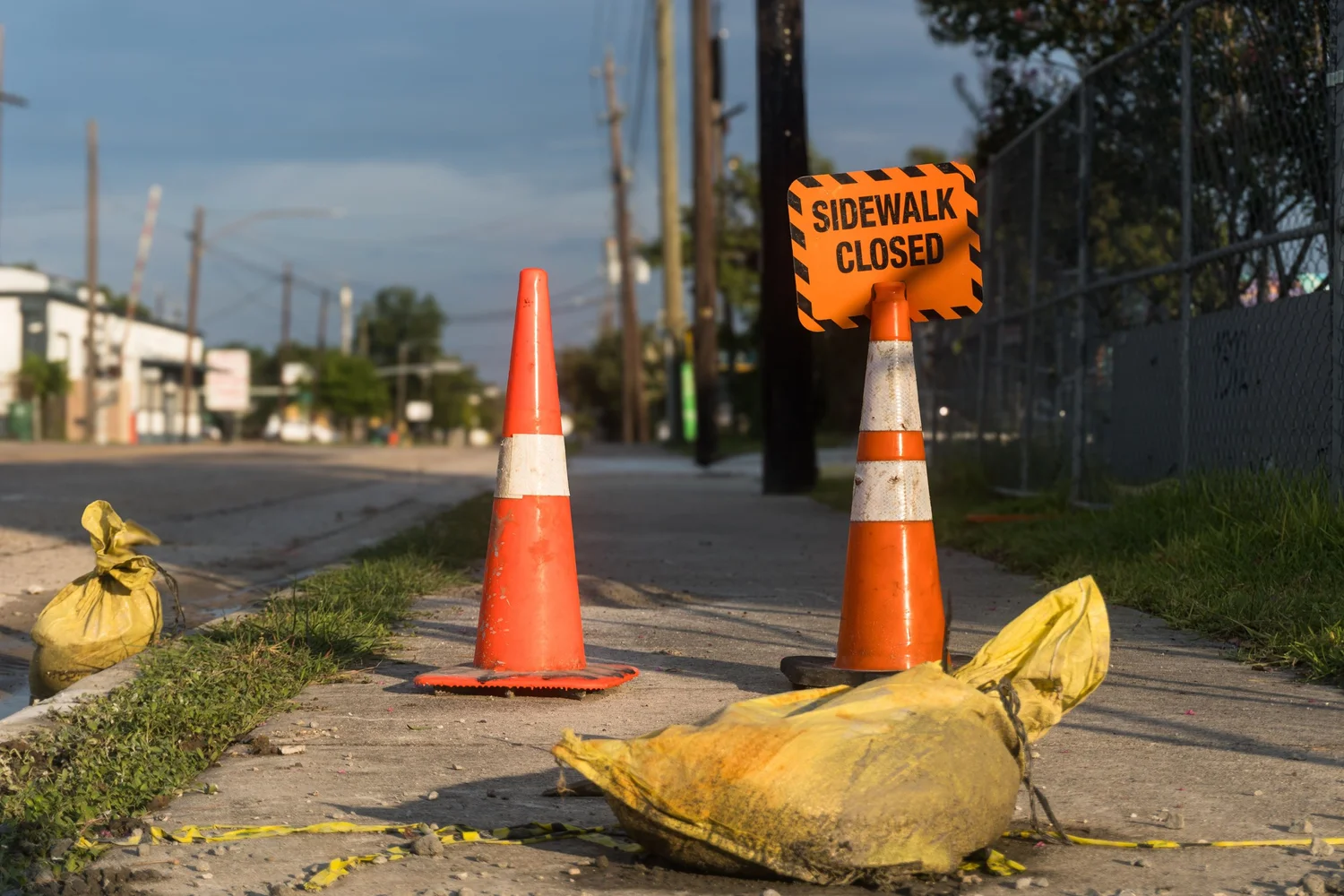 Traffic cones and a sidewalk closed sign blocking a sidewalk