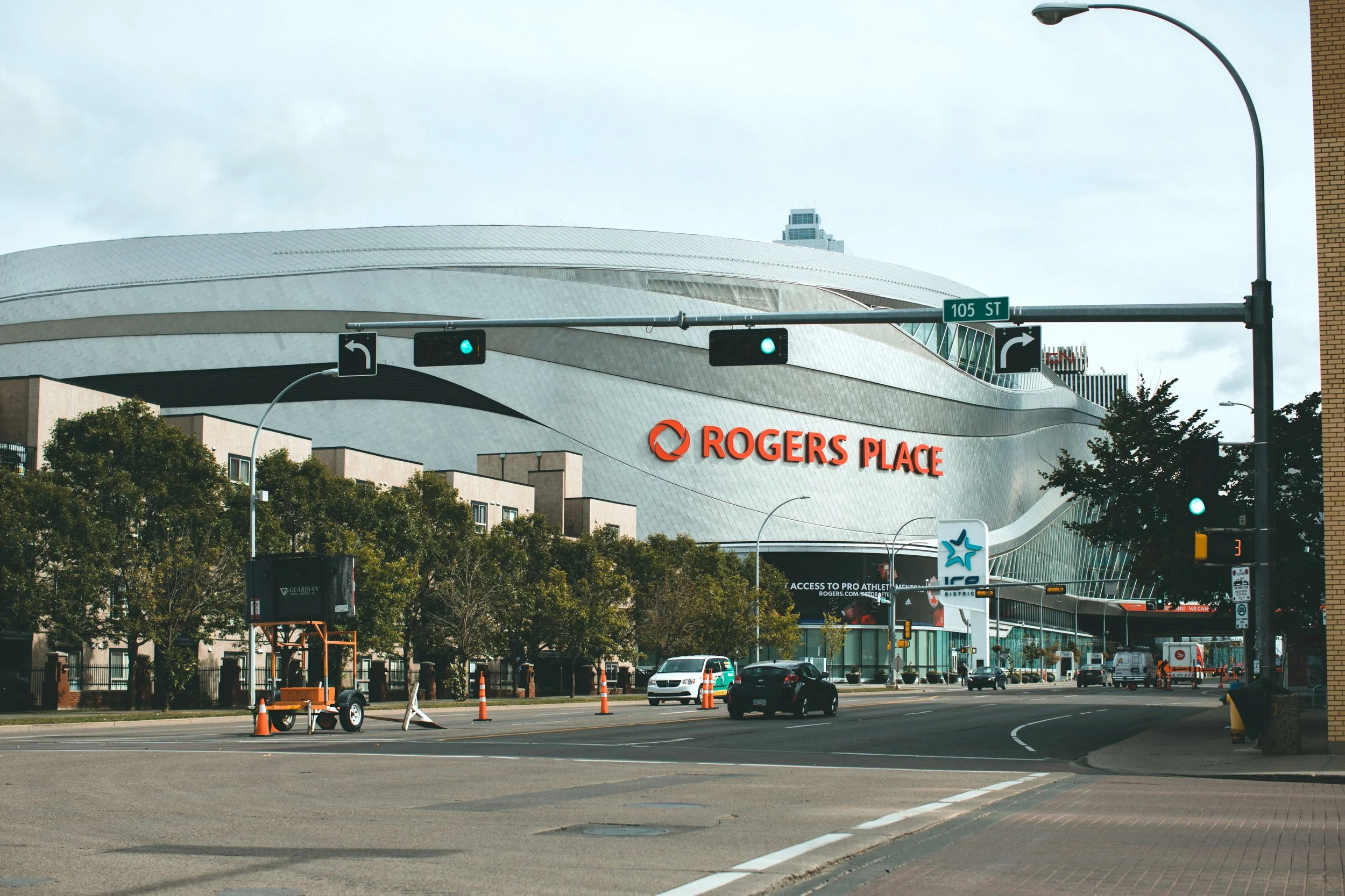 Rogers Place arena in downtown Edmonton with traffic cones and an arrow board on the street