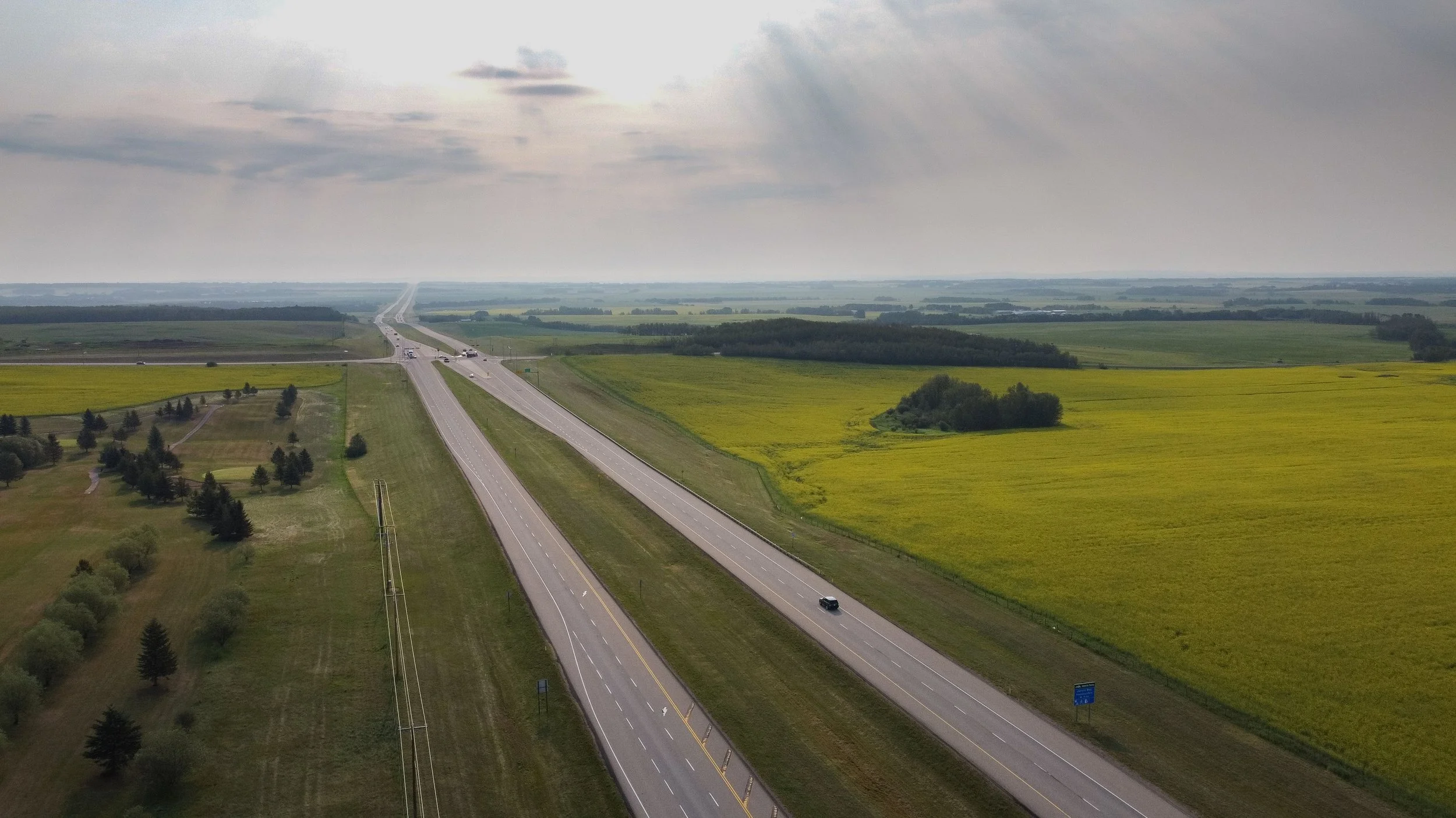 Aerial view of a divided Alberta highway running through farmland