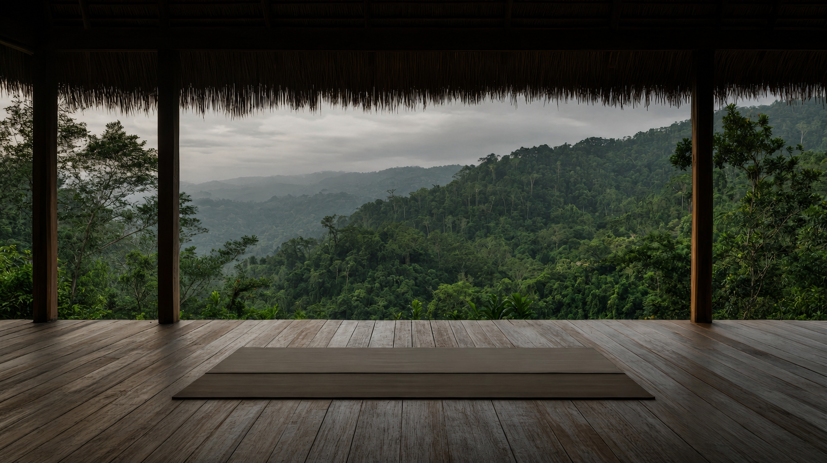Single rolled yoga mat on an open-air deck facing a rainforest mountain view