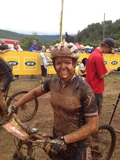 Amy Wakefield covered in mud and smiling after podiuming at the South African National XCM Championship 2014