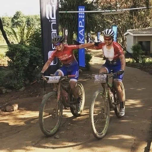 Amy Wakefield and Sam Sanders crossing the Sani2C finish line in Team Dormakaba kit, 2018