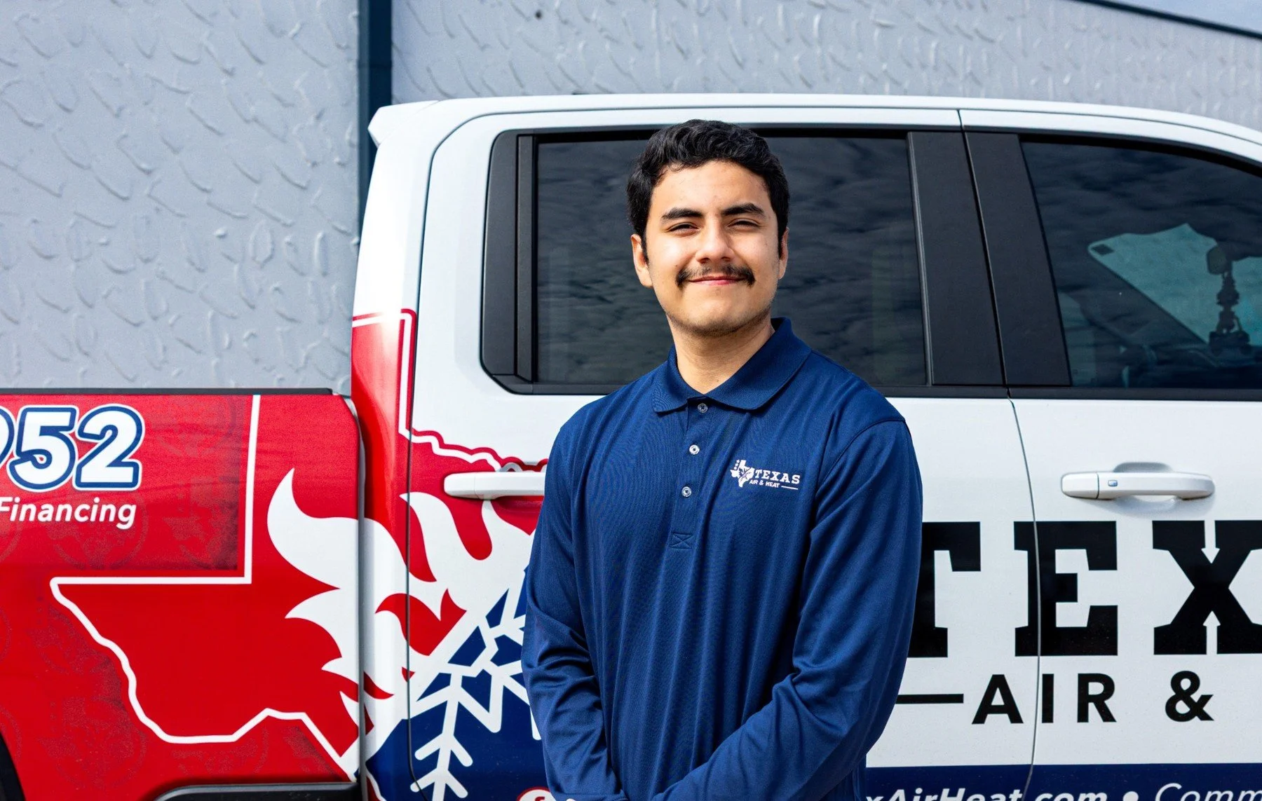 Texas Air & Heat technician standing in front of a branded company truck