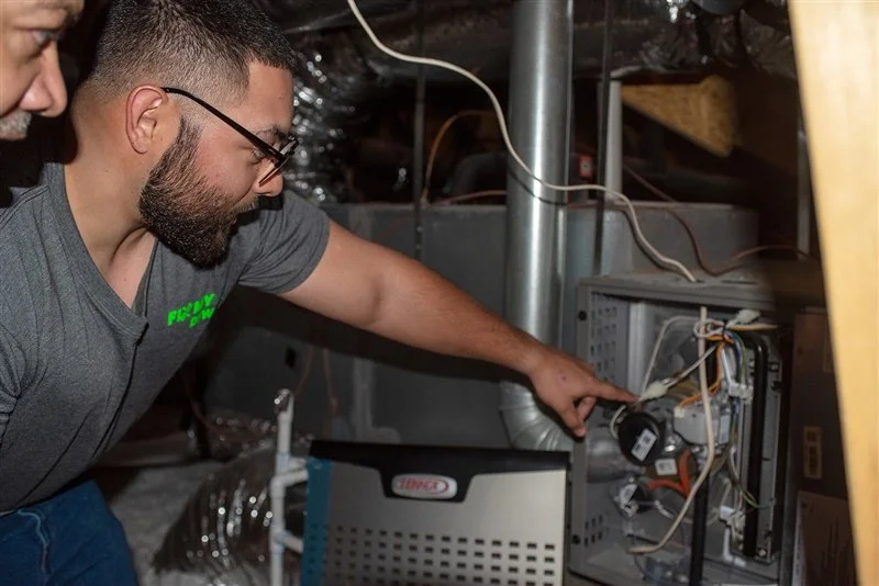 Fix My Air DFW technician inspecting a furnace in a Fort Worth home