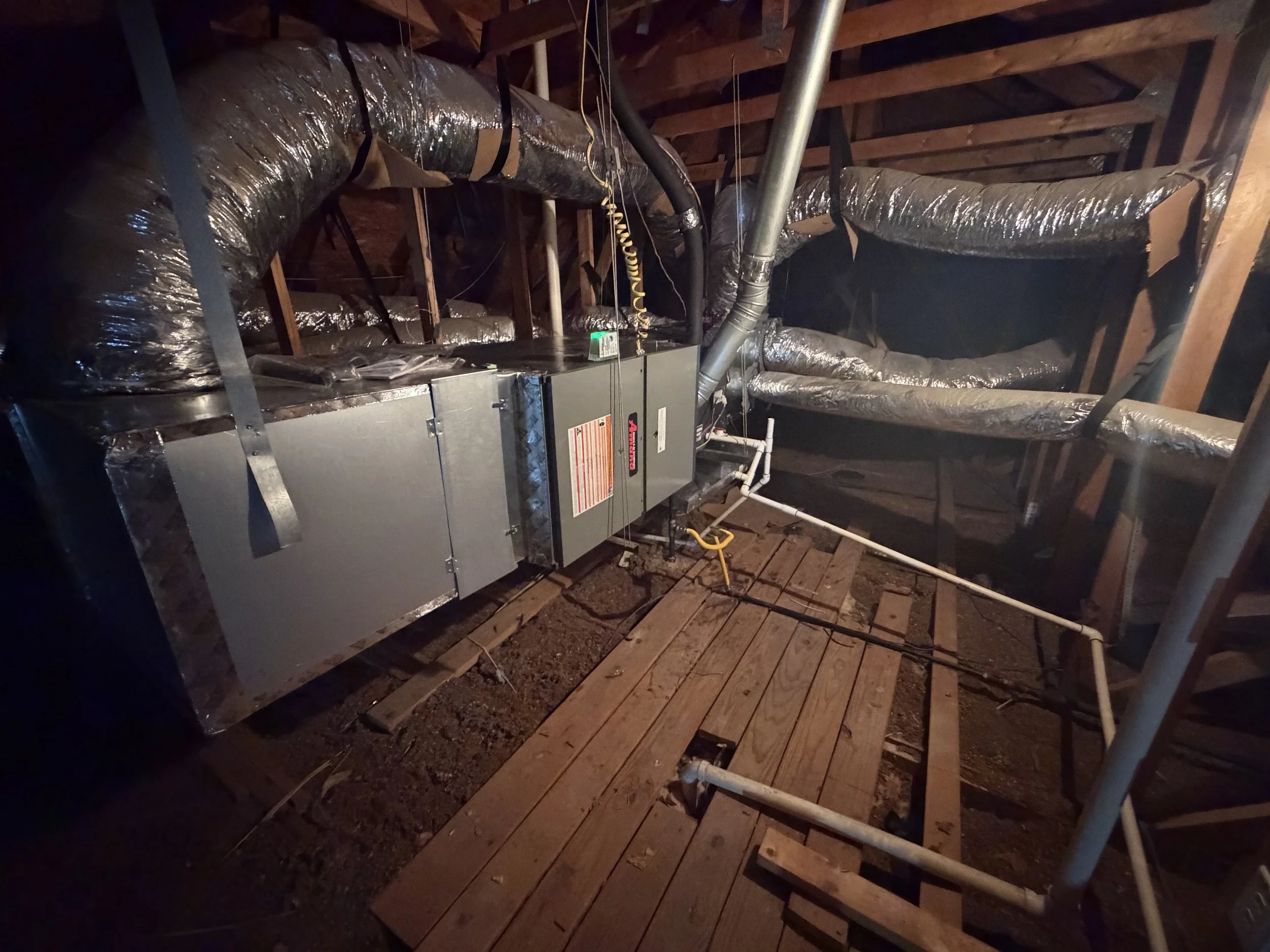 Fix My Air DFW technician inspecting an attic air handler and ductwork in a Fort Worth home