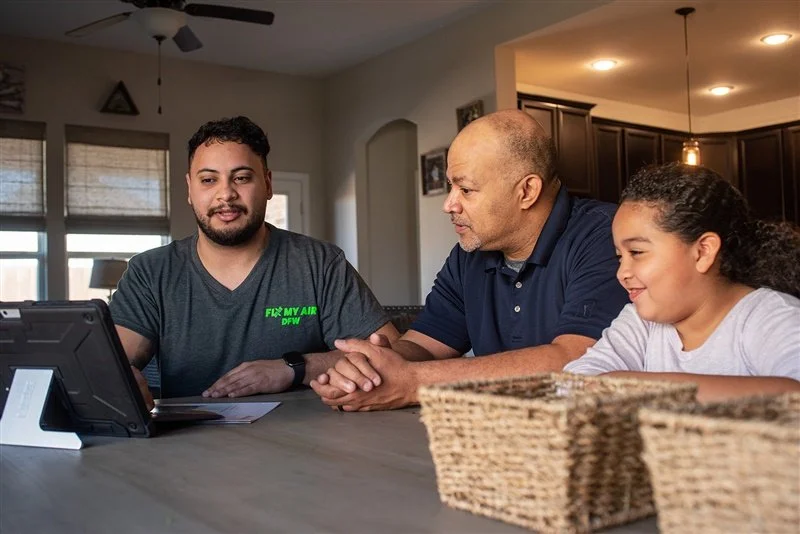A Fix My Air DFW technician walks a Fort Worth homeowner through the findings at her kitchen table
