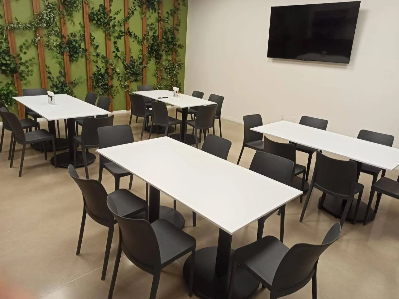 Comedor con mesas blancas y sillas negras