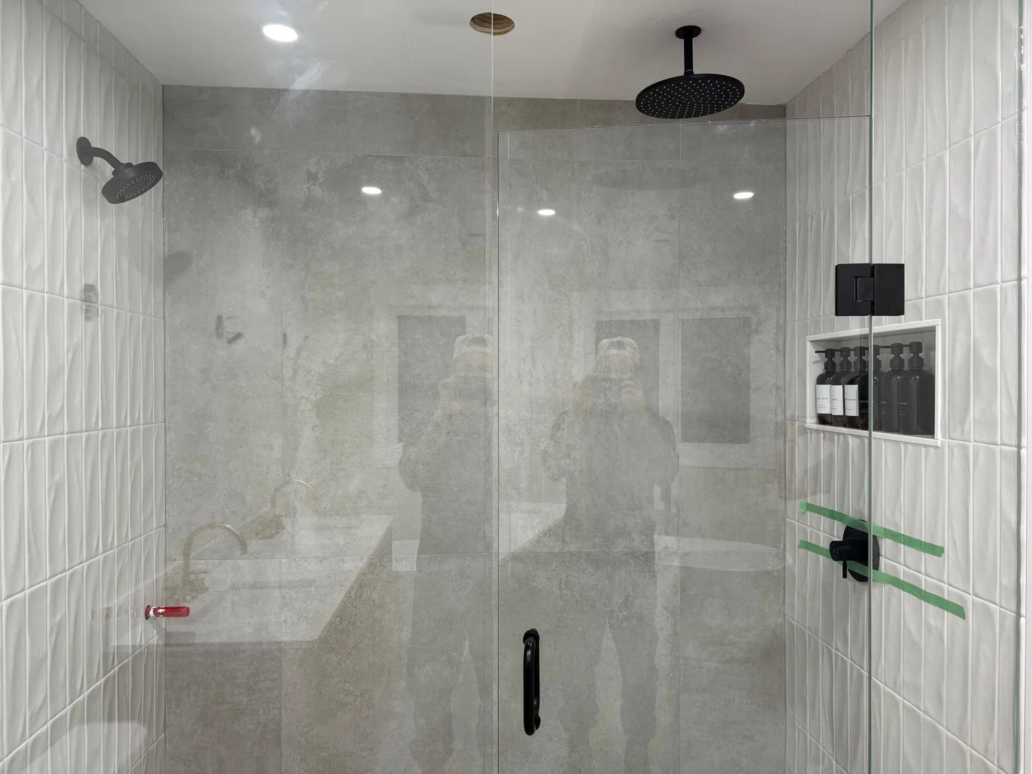 Finished marble shower with rainfall head and hand shower, plumbed by Seal Plumbing