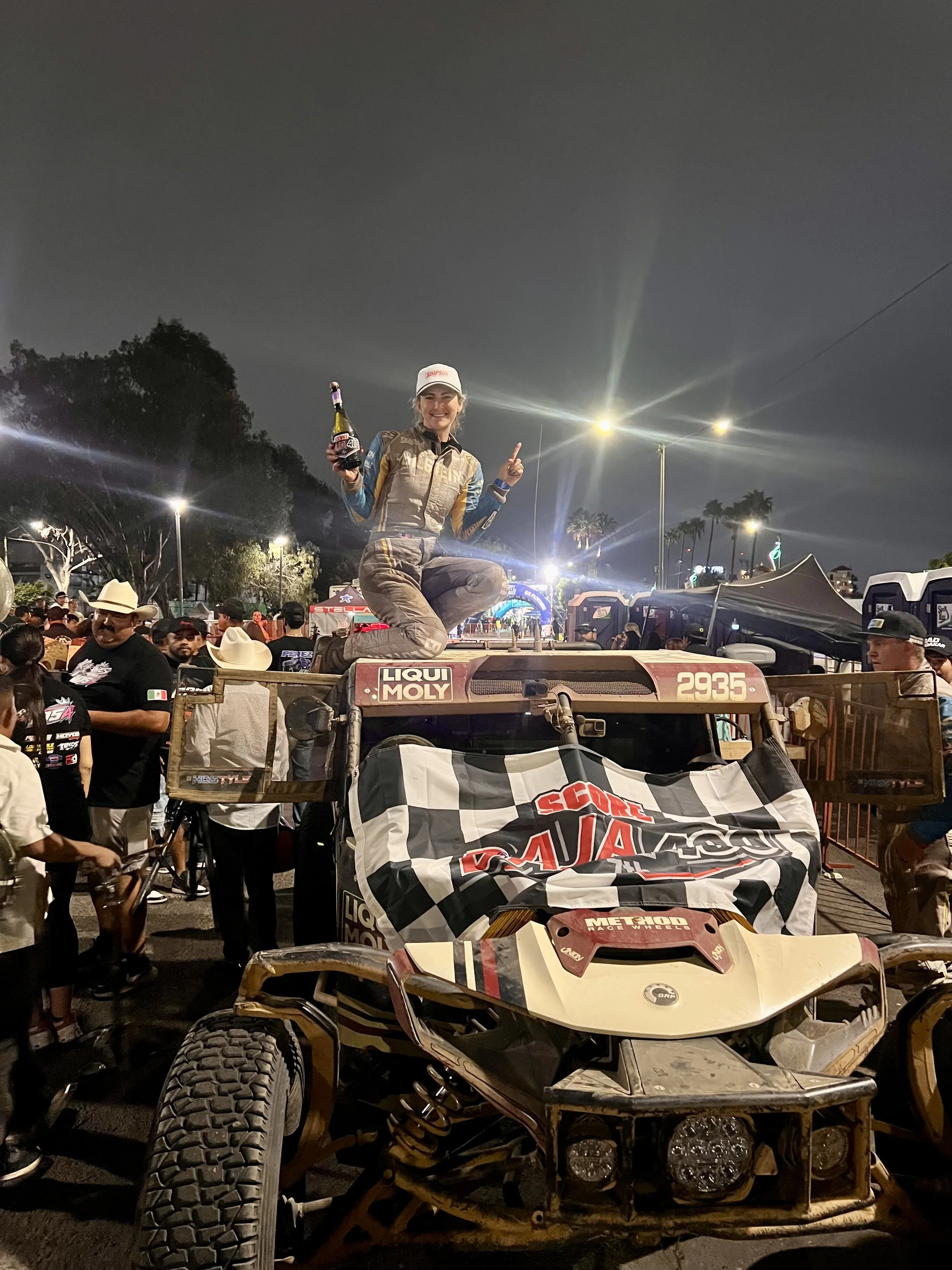 Emma Cornwell celebrating a SCORE Baja 400 win atop the race car