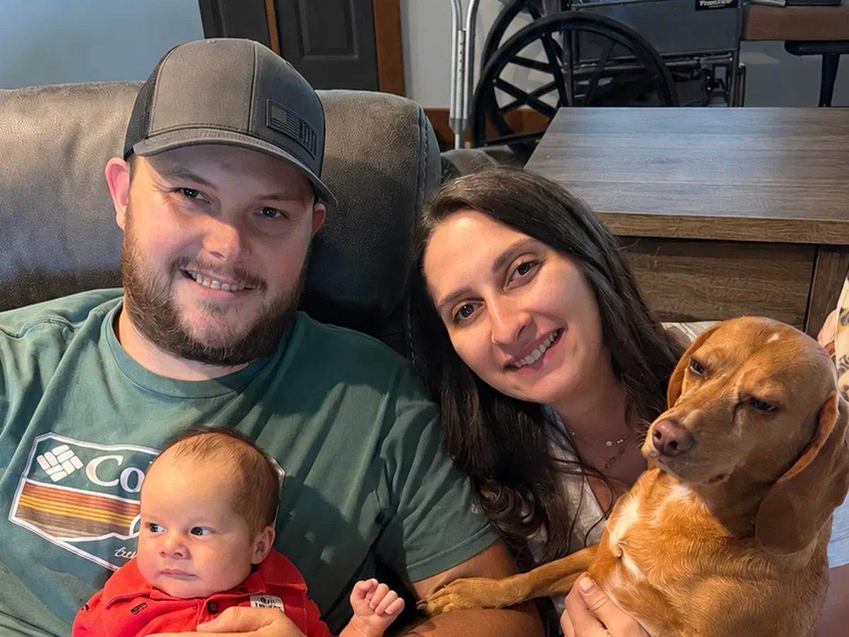 Kyle and Ashley Albert at home with their baby and dog