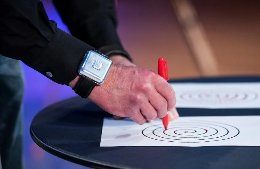 An early Encora prototype on a man's wrist as he draws a spiral