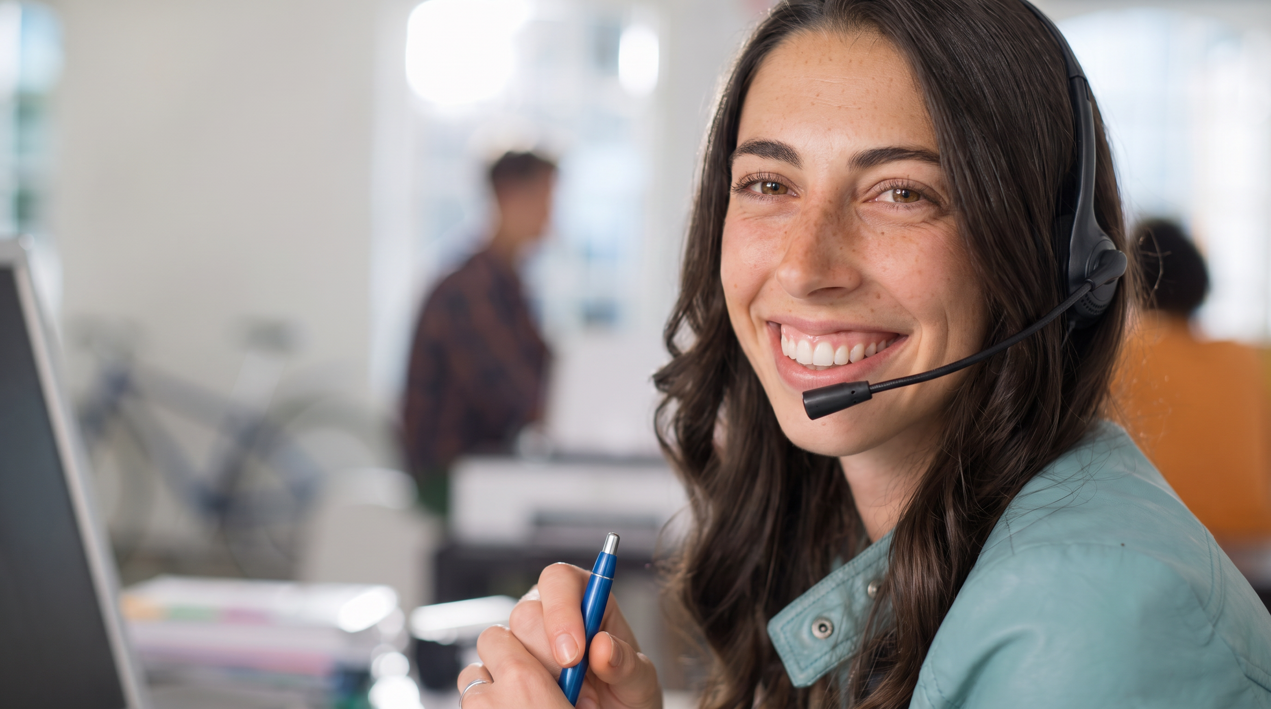 An Encora Patient Advocate smiling on a call at her desk