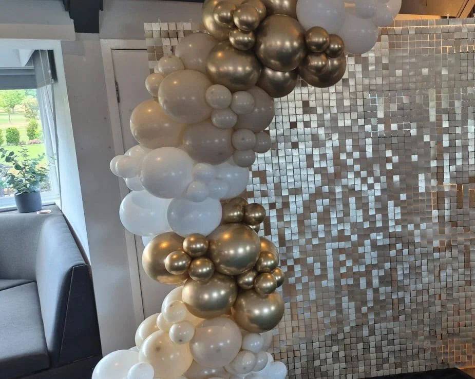 Balloon arch and sequin wall beside the bar for an engagement party