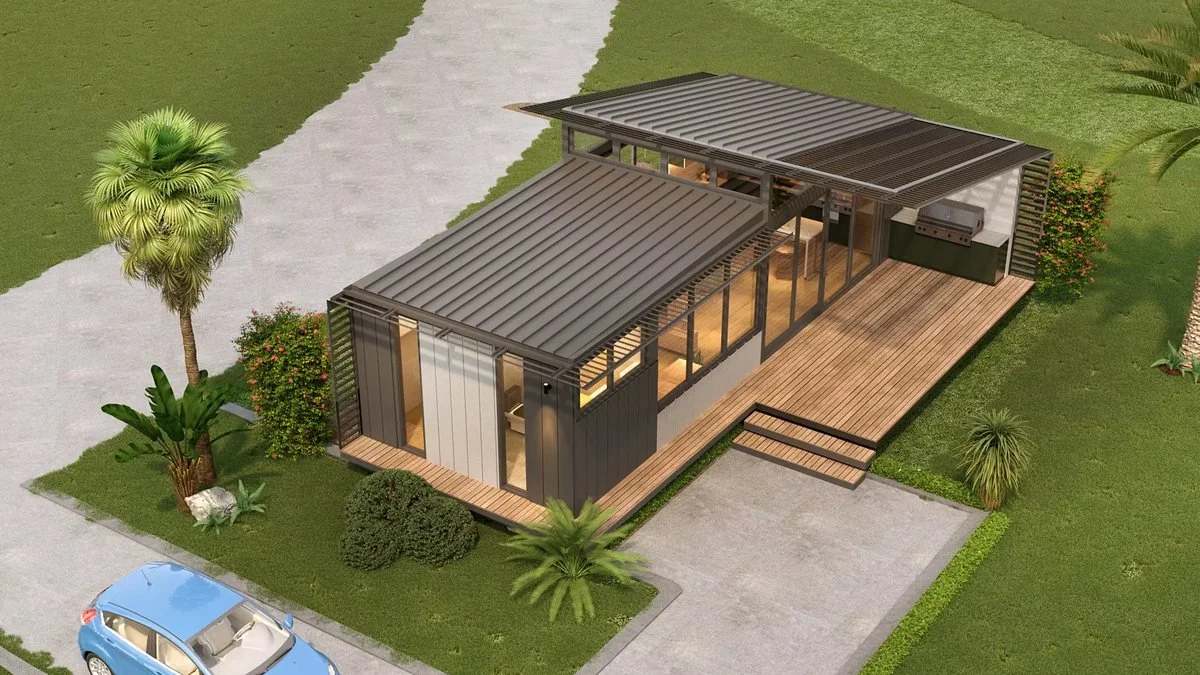 Freedom 55 exterior from above: skillion roofs, glazed living area and a timber deck in a landscaped garden.