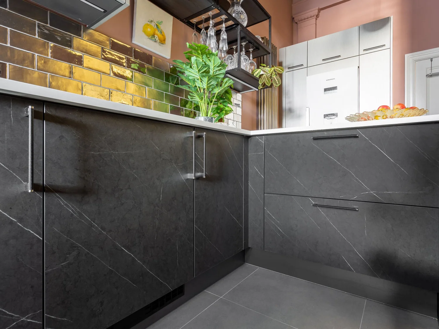 Dark kitchen cabinetry and silver Metro-style tiles in the Bristol Mansions renovation