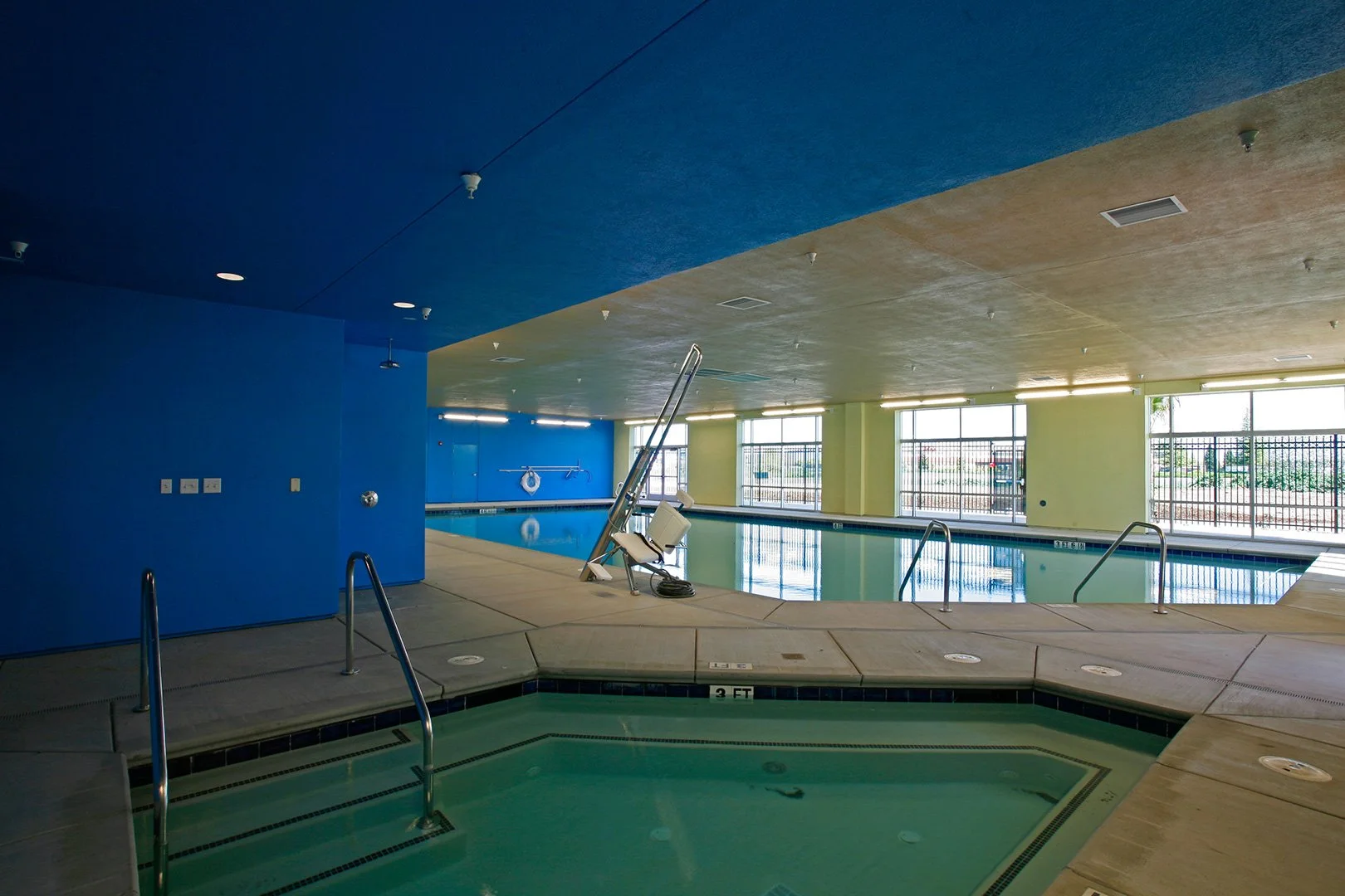 The spa, an octagonal sunken tub with stainless rails under a deep blue folded ceiling.
