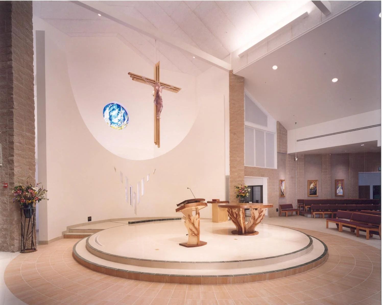 The altar and ambo from the side, on branching carved bases below the crucifix.