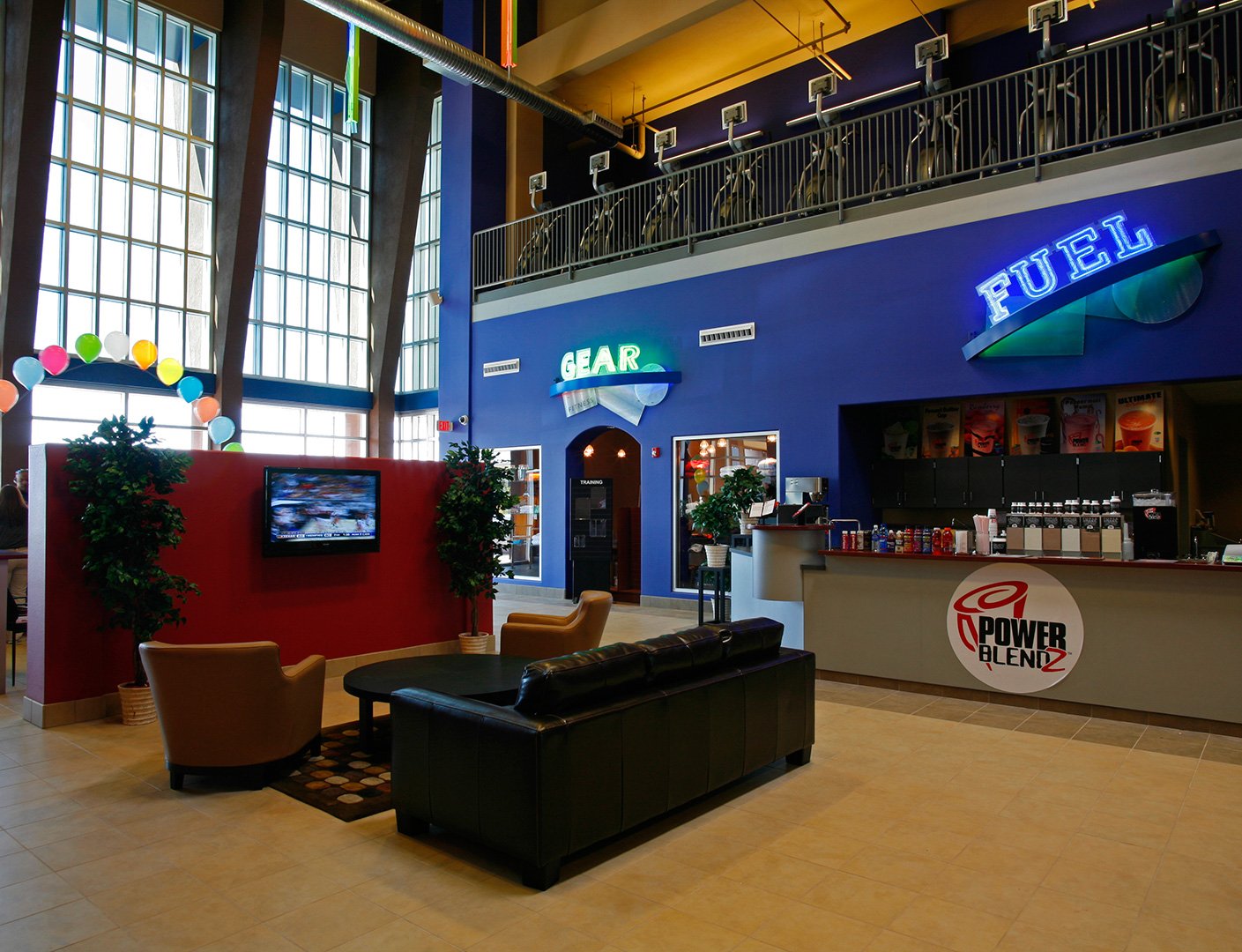 The lounge at floor level, leather sofas and armchairs on a tiled floor with clipped trees either side.