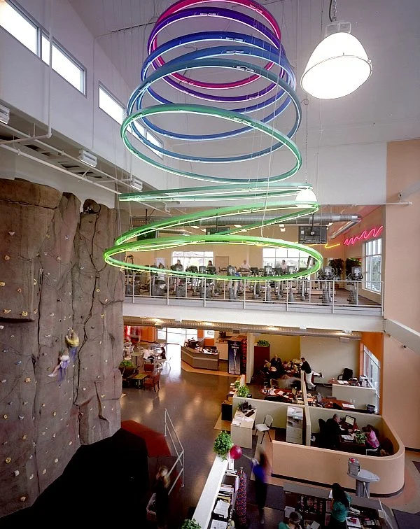 Neon rings hung over the cafe and lobby, the grey rock of the climbing wall rising at the left.