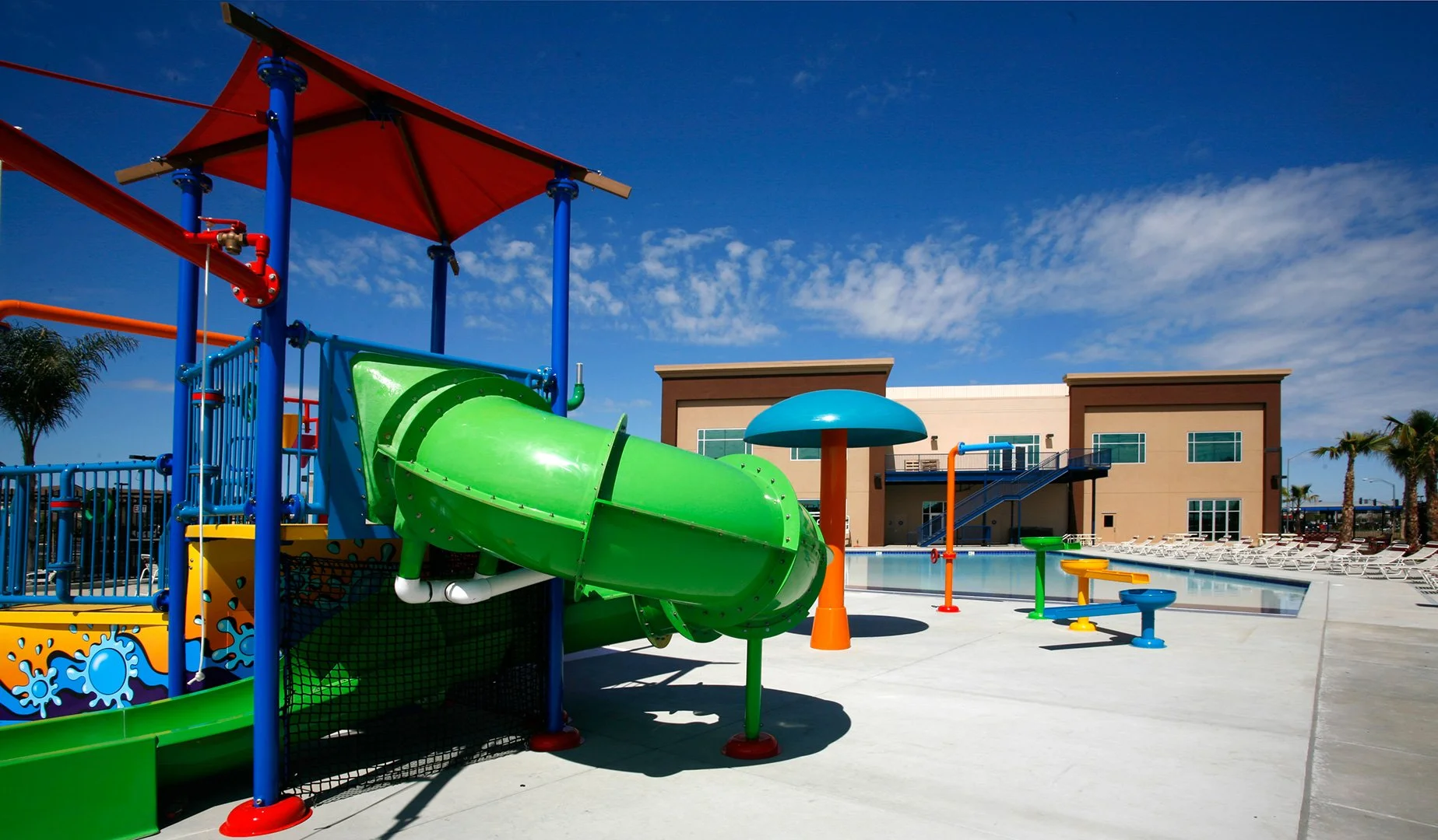 The spray ground, a green flume coiling from a red canopied tower over a turquoise mushroom fountain.