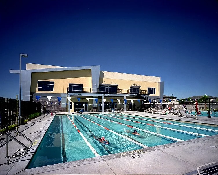 The lap pool along its length, lane ropes running away towards the two storey elevation behind the deck.