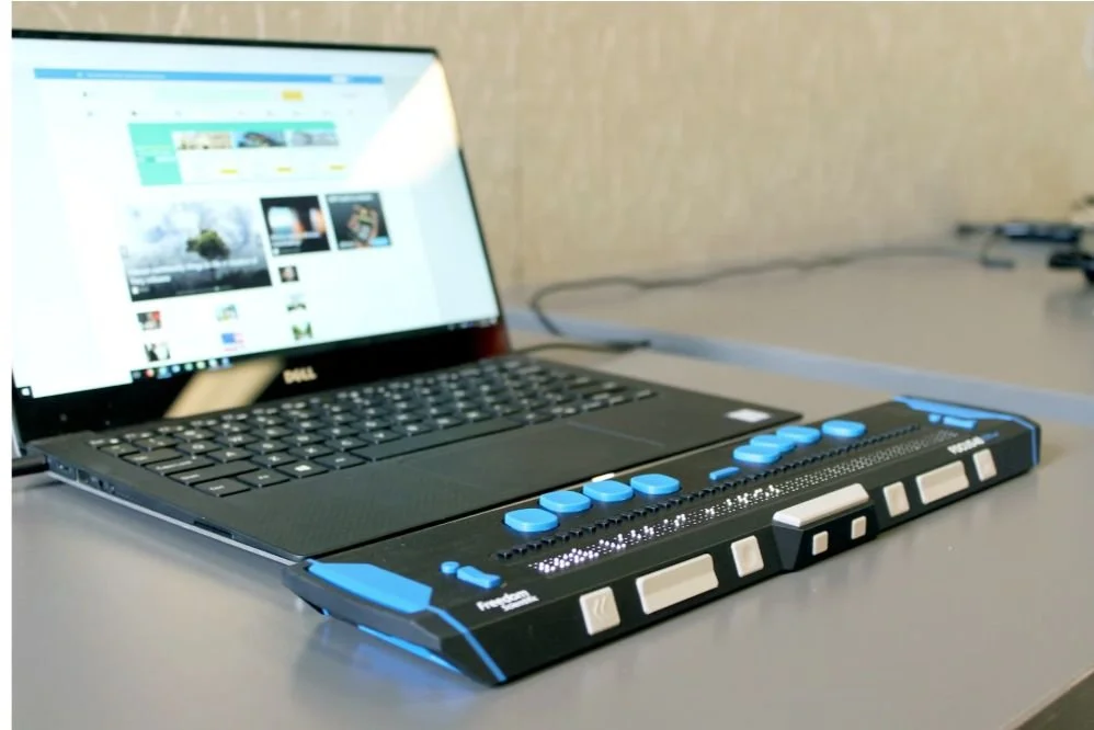 Laptop connected to a refreshable braille display.