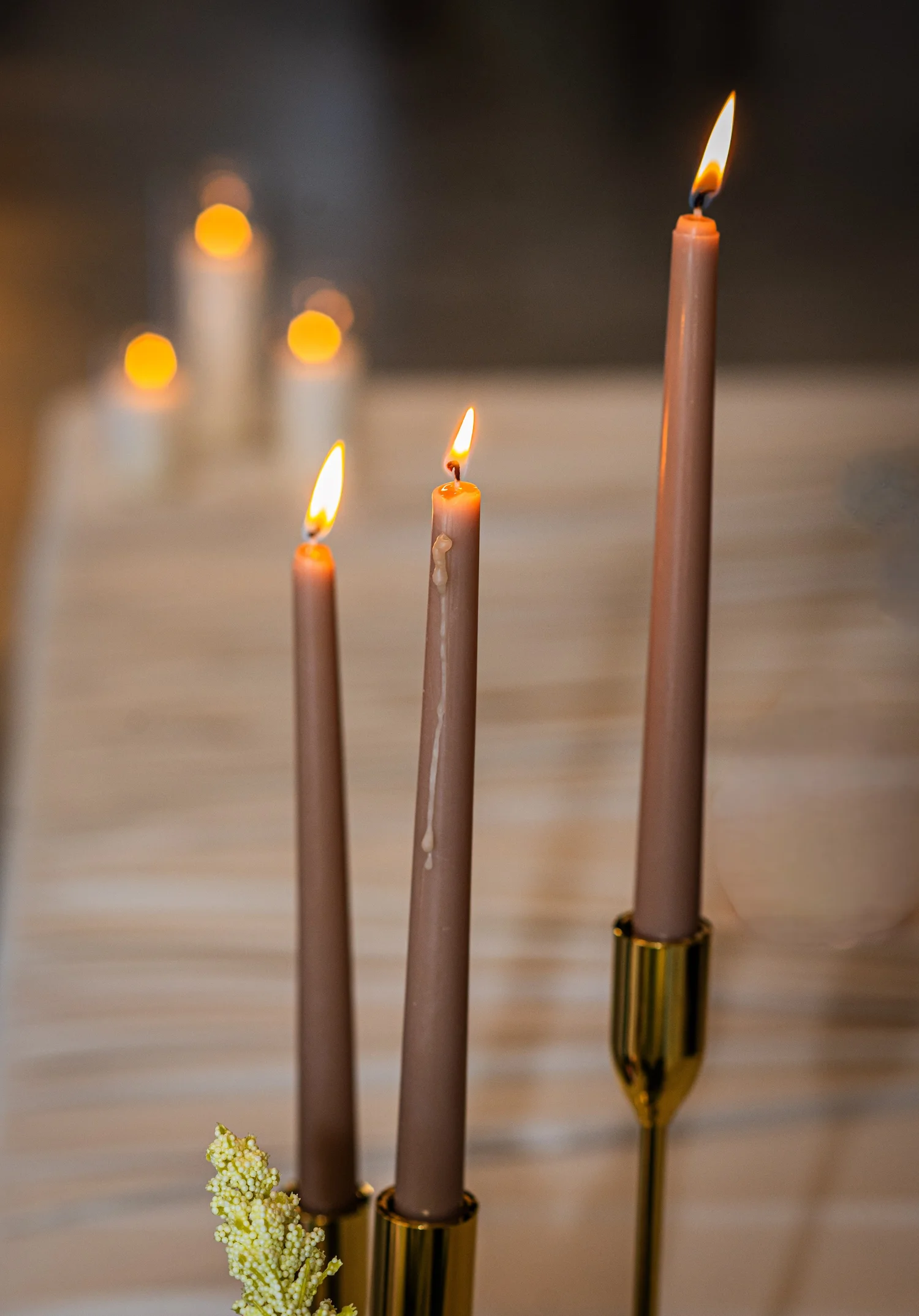 Tall taper candles glowing over a wedding table