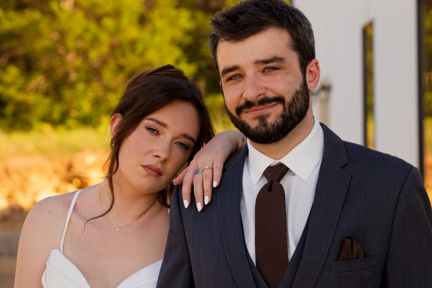 A bride and groom posing together in golden light