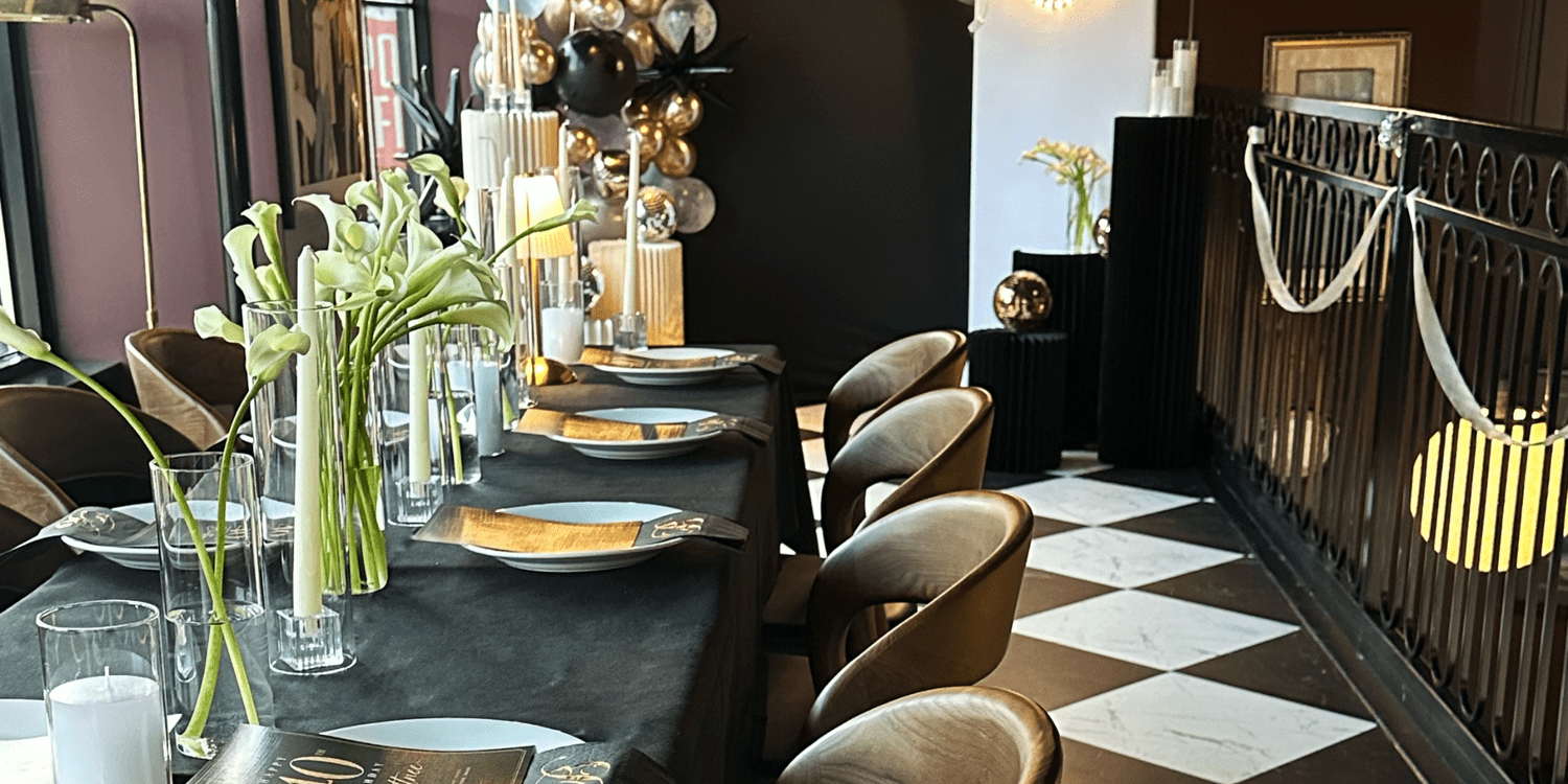 A candlelit 40th birthday dinner table with calla lilies and gold chairs