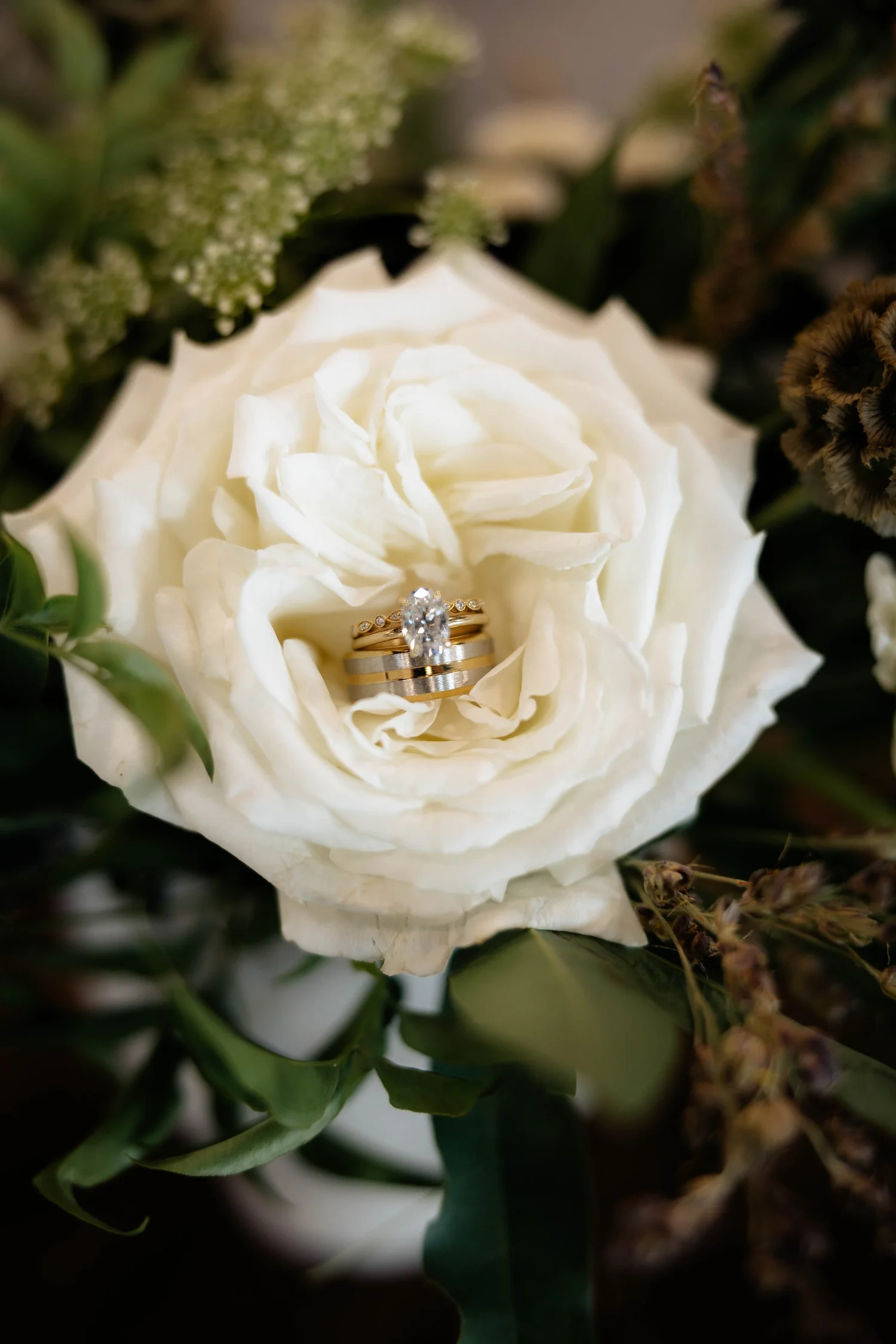 A wedding ring nestled in a white rose
