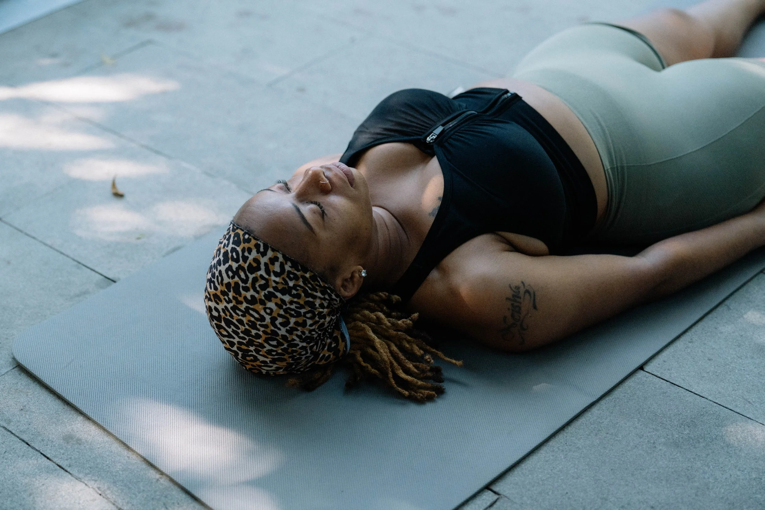 Kenisha B. sitting cross-legged, hand on heart