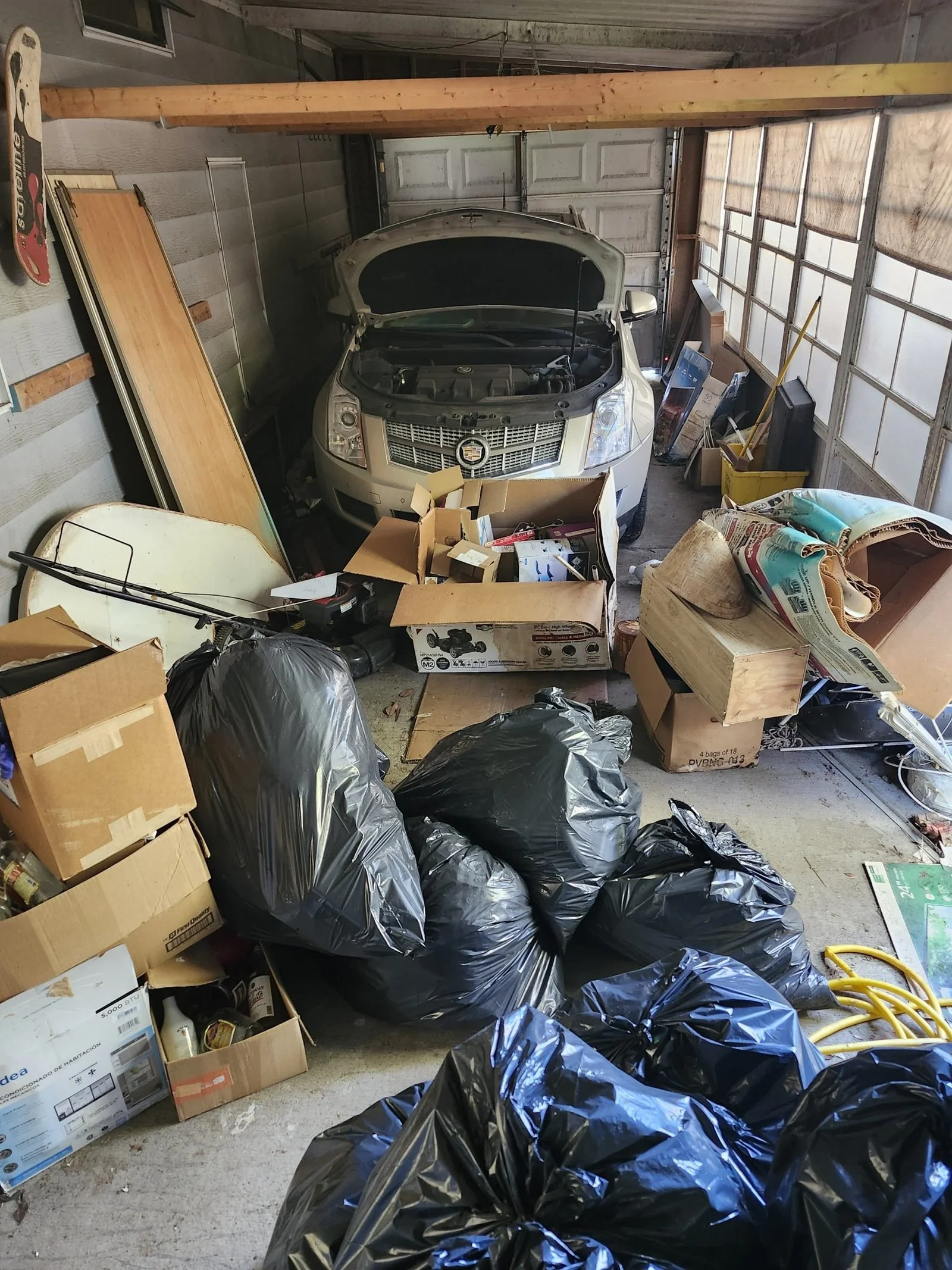 Garage filled with bags and boxes before a Polk Services cleanout.