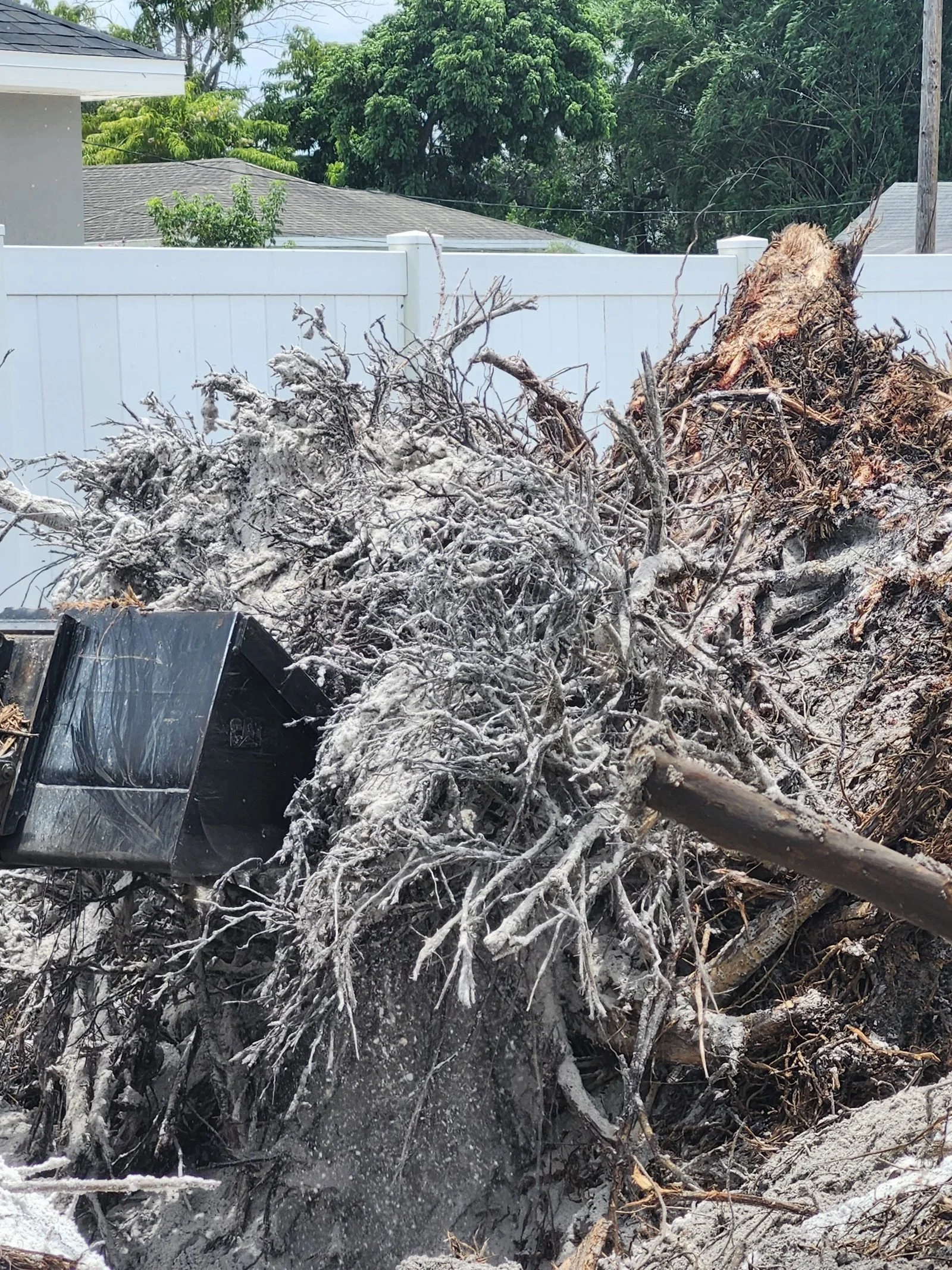 The Polk Services Kubota SCL1000 clearing storm debris on a Polk County property.