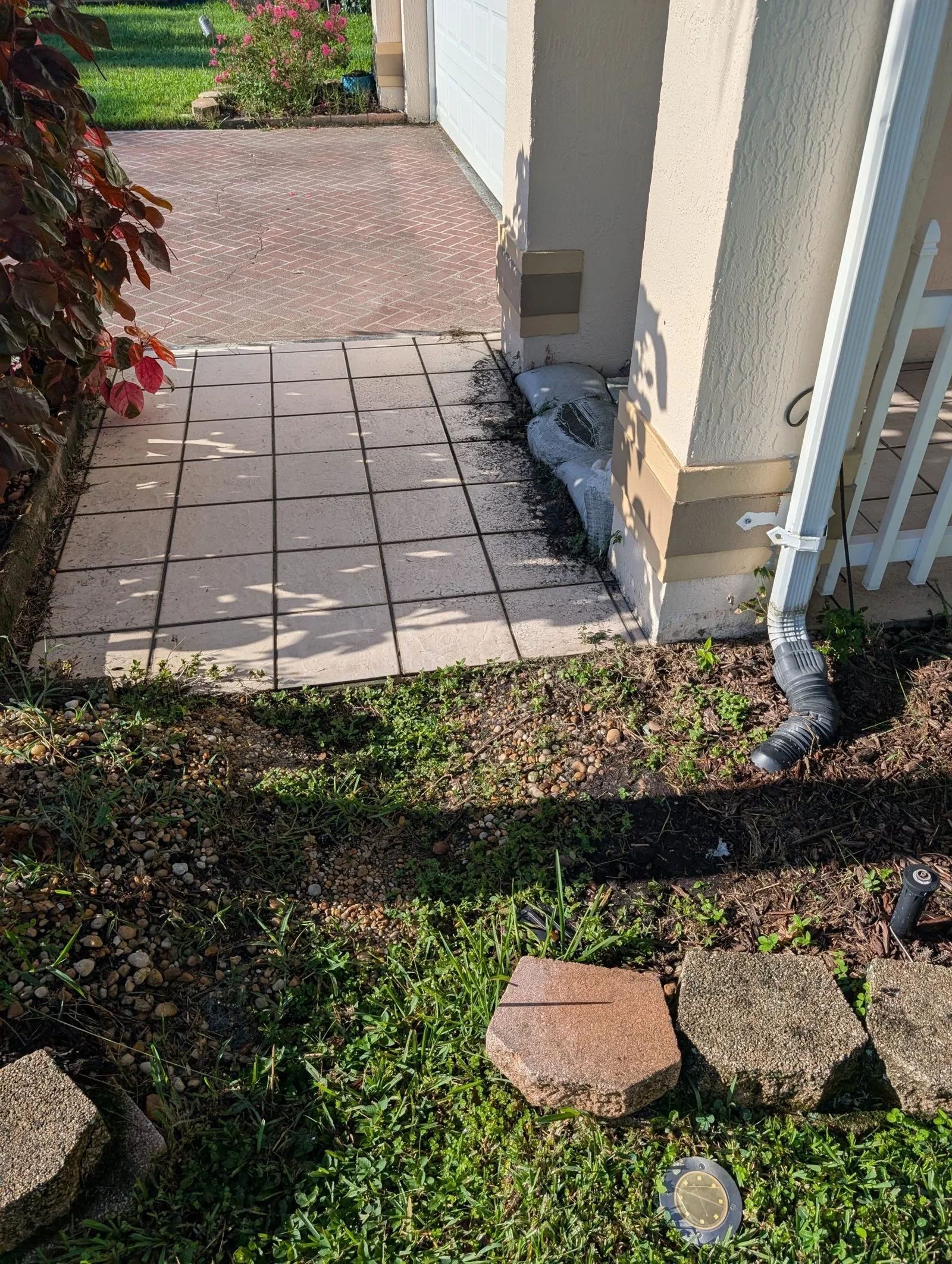 Bare dirt strip beside the patio before the Polk Services drainage work.