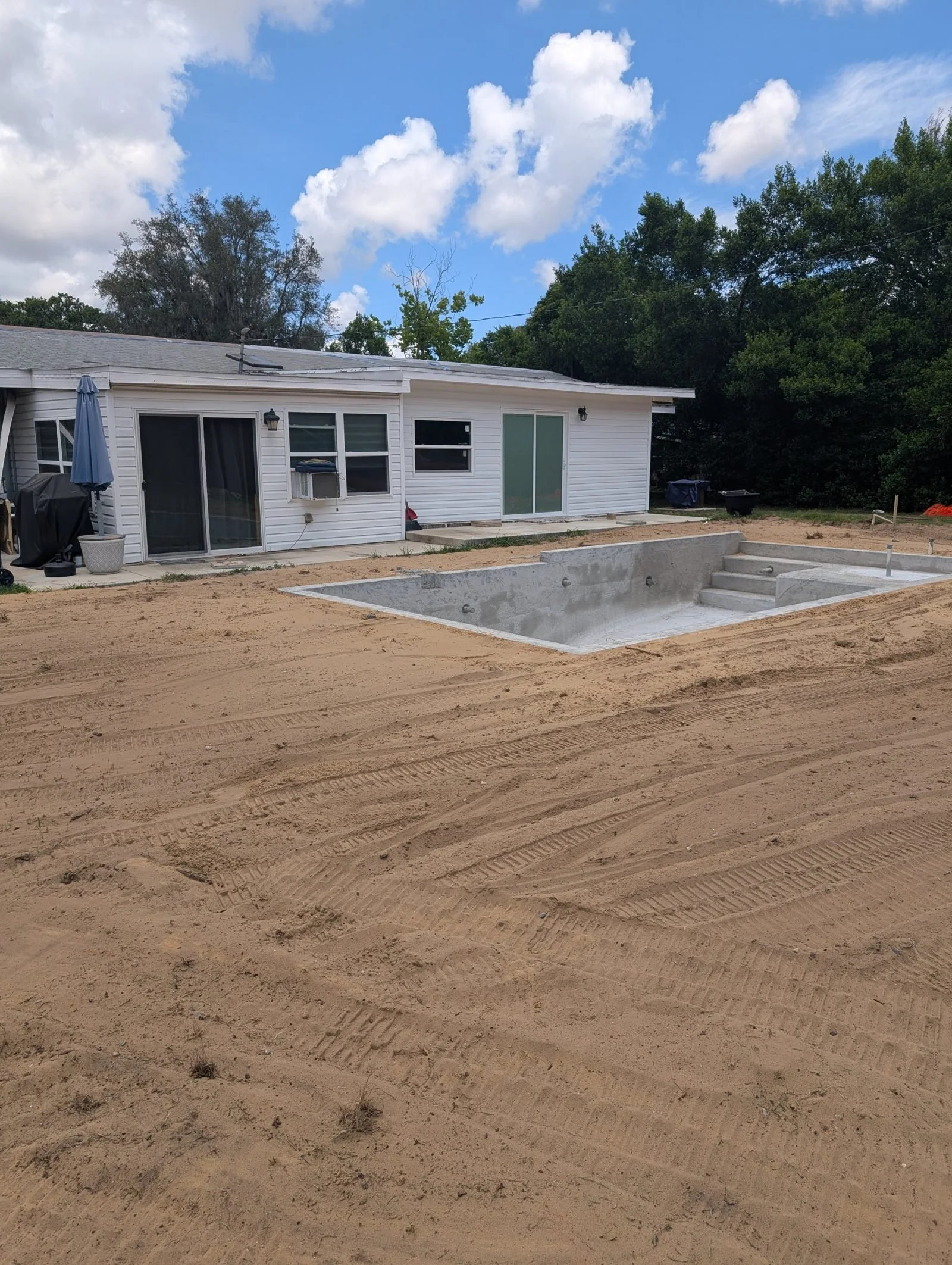 Yard around the pool graded smooth and level by Polk Services.